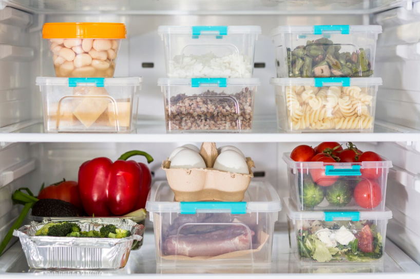 Meal prep for beginners using prepped ingredients stored in clear containers inside a fridge.