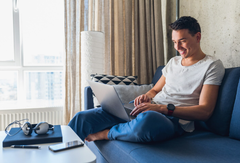 Man working on a laptop from home while managing a flexible side hustle for extra income.