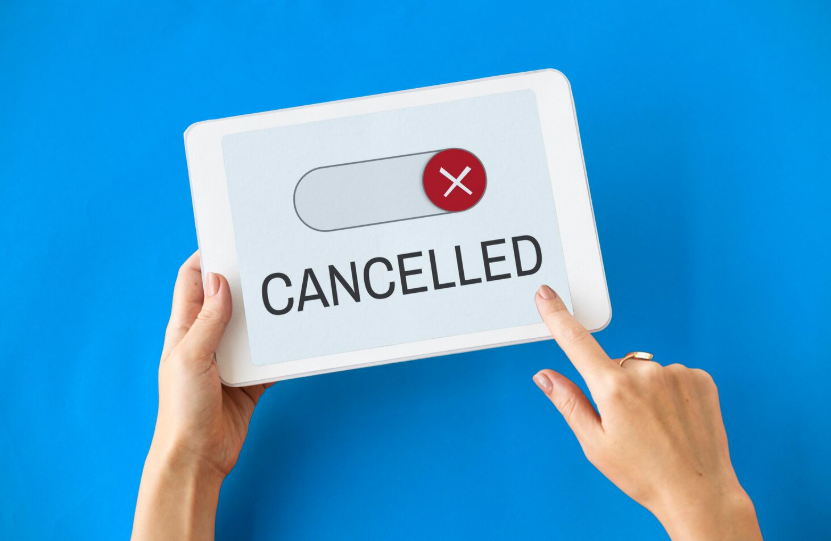 Person tapping a digital cancel button on a tablet to stop unwanted subscriptions.